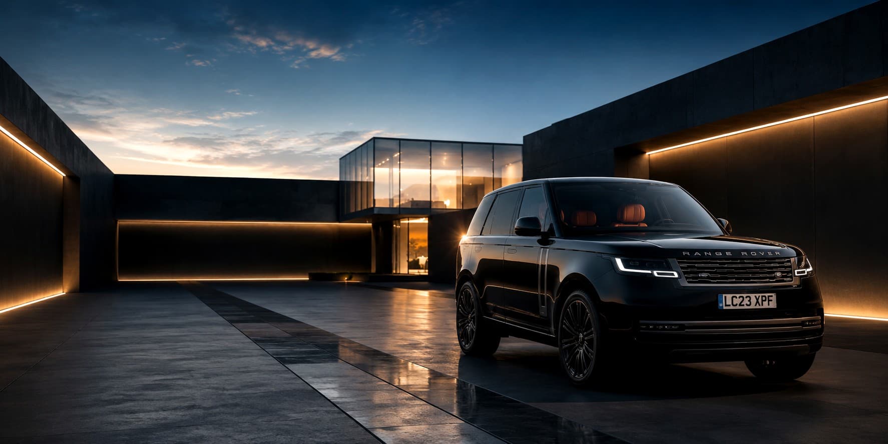 Black Range Rover parked outside a modern architectural home at dusk